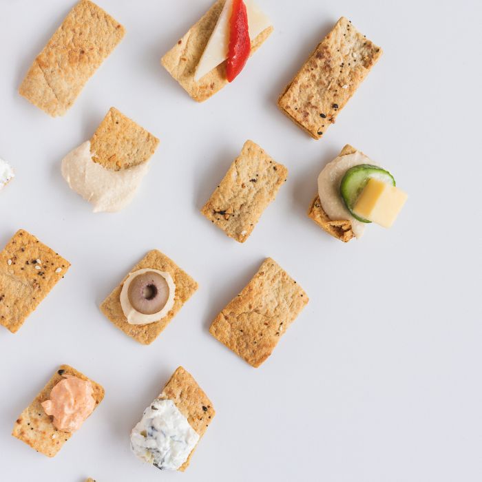 Image of Freekeh Harvest crackers with a variety of toppings.